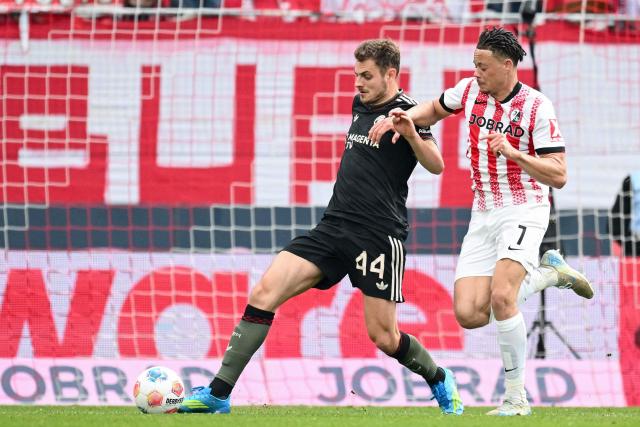 Bayern Munich's Croatian defender #44 Josip Stanisic (L) and Freiburg's German forward #07 Derry Scherhant vie for the ball during the German first division Bundesliga football match between SC Freiburg and FC Bayern Munich in Freiburg, southern Germany on April 4, 2026. (Photo by Silas STEIN / AFP) / DFL REGULATIONS PROHIBIT ANY USE OF PHOTOGRAPHS AS IMAGE SEQUENCES AND/OR QUASI-VIDEO