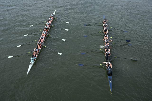 The Oxford crew celebrate (R) beside the defeated Cambridge crew (L) after the 80th Women's boat race between Oxford University and Cambridge University on the River Thames in London on April 4, 2026. (Photo by JUSTIN TALLIS / AFP)