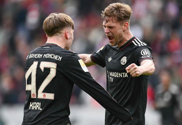 Bayern Munich's German midfielder #42 Lennart Karl (L) celebrates scoring the 2-3 goal with his teammate Bayern Munich's German midfielder #06 Joshua Kimmich during the German first division Bundesliga football match between SC Freiburg and FC Bayern Munich in Freiburg, southern Germany on April 4, 2026. (Photo by Silas STEIN / AFP) / DFL REGULATIONS PROHIBIT ANY USE OF PHOTOGRAPHS AS IMAGE SEQUENCES AND/OR QUASI-VIDEO