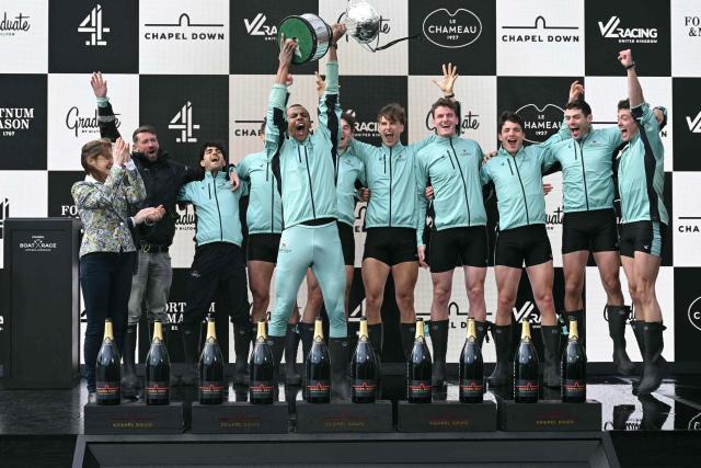 Cambridge's French president, Noam Mouelle lifts the trophy as they celebrate on the podium after the 171th men's boat race between Oxford University and Cambridge University on the River Thames in London on April 4, 2026. (Photo by JUSTIN TALLIS / AFP)