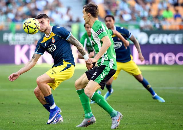 Espanyol's Spanish forward #09 Roberto Fernandez (L) is challenged by Real Betis' Spanish defender #03 Diego Llorente during the Spanish league football match between Real Betis and RCD Espanyol at Benito Villamarin Stadium in Seville on April 4, 2026. (Photo by CRISTINA QUICLER / AFP)