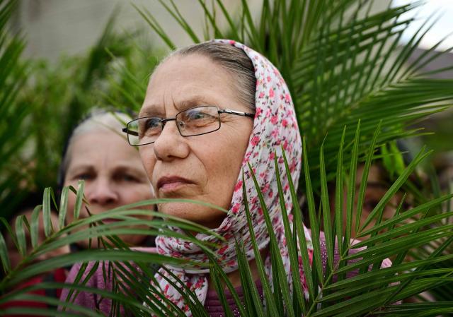 Romanian orthodox believers take part in the Palm Sunday March in Bucharest on April 4, 2026. (Photo by Daniel MIHAILESCU / AFP)