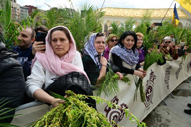 Romanian orthodox believers take part in the Palm Sunday March in Bucharest on April 4, 2026. (Photo by Daniel MIHAILESCU / AFP)