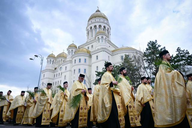 Romanian orthodox priests take part in the Palm Sunday March next to the National Cathedral in Bucharest on April 4, 2026. (Photo by Daniel MIHAILESCU / AFP)