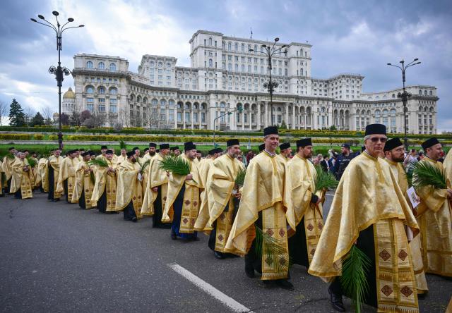 Romanian orthodox priests take part in the Palm Sunday March next to the Romanian Parliament in Bucharest on April 4, 2026. (Photo by Daniel MIHAILESCU / AFP)