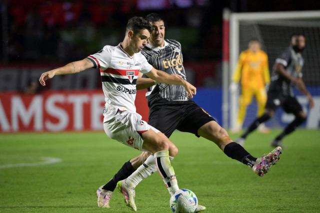 (FILES) Sao Paulo's midfielder #08 Oscar (L) and Libertad's midfielder #06 Alvaro Campuzano fight for the ball during the Copa Libertadores group stage football match between Brazil's Sao Paulo and Paraguay's Libertad at the Morumbi stadium in Sao Paulo, Brazil, on May 14, 2025. Former Brazil international Oscar was forced to retire at the age of 34 due to cardiac issues, his club Sao Paulo confirmed on April 4, 2026. (Photo by NELSON ALMEIDA / AFP)