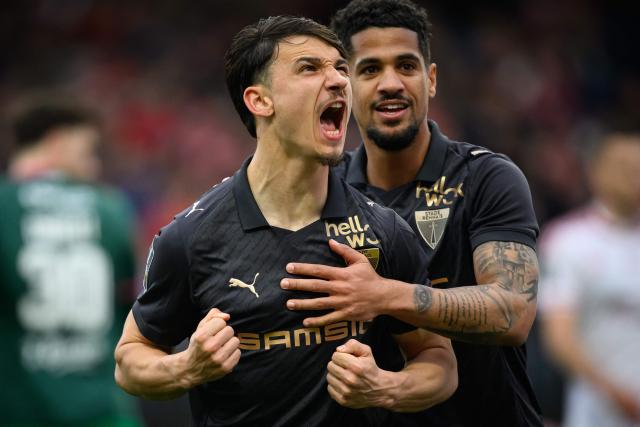 Rennes' French forward #09 Esteban Lepaul (L) celebrates with Rennes' French forward #10 Ludovic Blas after scoring a penalty shot during the French L1 football match between Stade Brestois 29 (Brest) and Stade Rennais FC  at the Stade Francis-Le-Ble in Brest, western France, on April 4, 2026. (Photo by Loic VENANCE / AFP)