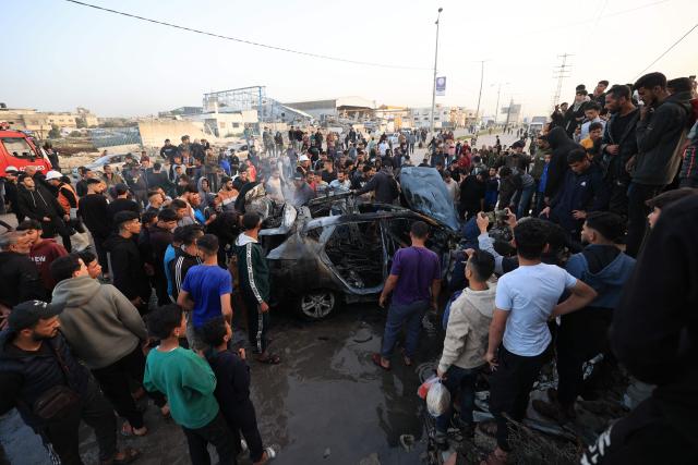 Palestinians inspect a vehicle targeted by an Israeli strike in Maghazi camp for Palestinian refugees in the central Gaza Strip on April 4, 2026. Since October 10, a fragile US-sponsored truce in Gaza has largely halted the fighting between Israeli forces and Hamas, but both sides have alleged frequent violations. (Photo by Eyad Baba / AFP)