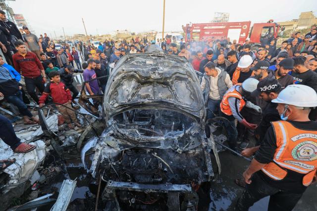 First responders and Plestinians inspect a vehicle targered by an Israeli strike in Maghazi camp for Palestinian refugees in the central Gaza Strip on April 4, 2026. Since October 10, a fragile US-sponsored truce in Gaza has largely halted the fighting between Israeli forces and Hamas, but both sides have alleged frequent violations. (Photo by Eyad Baba / AFP)