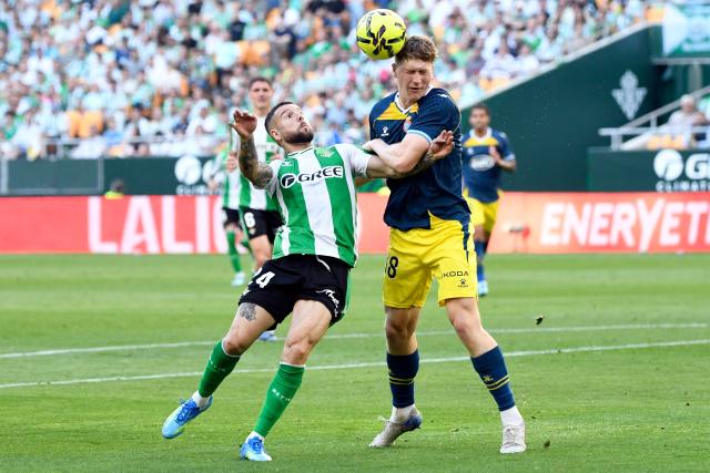 Real Betis' Spanish defender #24 Aitor Ruibal Garcia (L) and Espanyol's German defender #38 Clemens Riedel vie for a header during the Spanish league football match between Real Betis and RCD Espanyol at Benito Villamarin Stadium in Seville on April 4, 2026. (Photo by CRISTINA QUICLER / AFP)