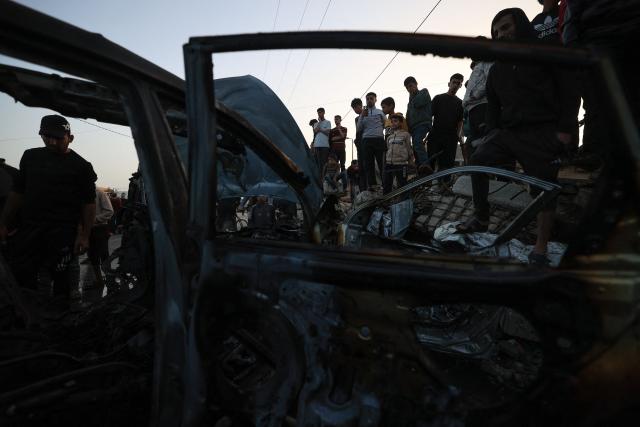 Palestinians inspect a vehicle targeted by an Israeli strike in Maghazi camp for Palestinian refugees in the central Gaza Strip on April 4, 2026. Since October 10, a fragile US-sponsored truce in Gaza has largely halted the fighting between Israeli forces and Hamas, but both sides have alleged frequent violations. (Photo by Eyad Baba / AFP)
