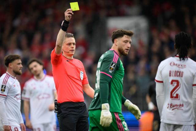 Brest's French goalkeeper #30 Gregoire Coudert (R) receives a yellow card during the French L1 football match between Stade Brestois 29 (Brest) and Stade Rennais FC  at the Stade Francis-Le-Ble in Brest, western France, on April 4, 2026. (Photo by Loic VENANCE / AFP)