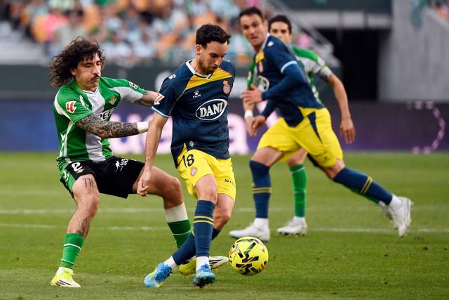 Real Betis' Spanish defender #02 Hector Bellerin and Espanyol's Spanish midfielder #08 Edu Exposito fight for the ball during the Spanish league football match between Real Betis and RCD Espanyol at Benito Villamarin Stadium in Seville on April 4, 2026. (Photo by CRISTINA QUICLER / AFP)