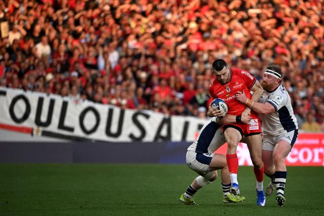 Toulouse's Scottish full back Blair Kinghorn (C) is tackled during the European Rugby Champions Cup round of 16 rugby union match between Stade Toulousain and Bristol at the Ernest-Wallon stadium in Toulouse, south-western France on April 4, 2026. (Photo by Matthieu RONDEL / AFP)