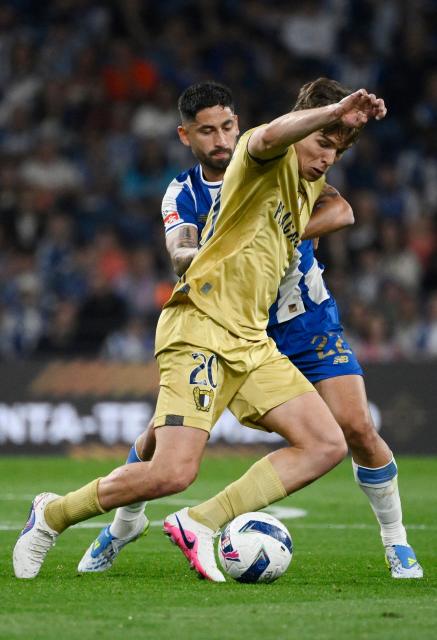 FC Famalicão's Portuguese midfielder #20 Gustavo Sa and FC Porto's Argentine midfielder #22 Alan Varela fight for the ball during the Portuguese League football match between FC Porto and FC Famalicao at Dragao stadium in Porto on April 4, 2026. (Photo by Miguel RIOPA / AFP)