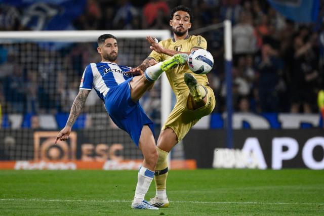 FC Porto's Argentine midfielder #22 Alan Varela (L) and FC Famalicão's French forward #12 Simon Elisor fight for the ball during the Portuguese League football match between FC Porto and FC Famalicao at Dragao stadium in Porto on April 4, 2026. (Photo by Miguel RIOPA / AFP)