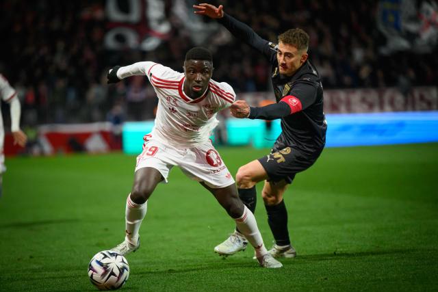 Brest's Senegalese forward #99 Pathe Mboup (L) fights for the ball with Rennes' French midfielder #21 Valentin Rongier during the French L1 football match between Stade Brestois 23 and Stade Rennais at the Francis-Le-Ble stadium in Brest, western France, on April 4, 2026. (Photo by Loic VENANCE / AFP)