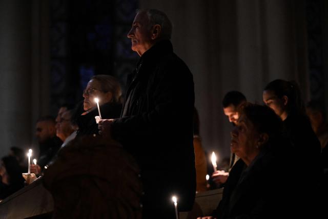 Christian worshippers hold candles as they attend an Easter Vigil at the Cathedral of St. Mother Teresa in Pristina, Kosovo on April 4, 2026. (Photo by Armend NIMANI / AFP)