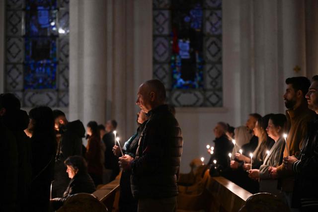 Christian worshippers hold candles as they attend an Easter Vigil at the Cathedral of St. Mother Teresa in Pristina, Kosovo on April 4, 2026. Armend NIMANI / AFP (Photo by Armend NIMANI / AFP)