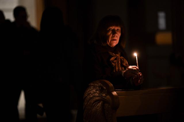 A Christian worshipper holds a candle as she attends an Easter Vigil at the Cathedral of St. Mother Teresa in Pristina, Kosovo on April 4, 2026, as part of the Holy Week celebrations. (Photo by Armend NIMANI / AFP)