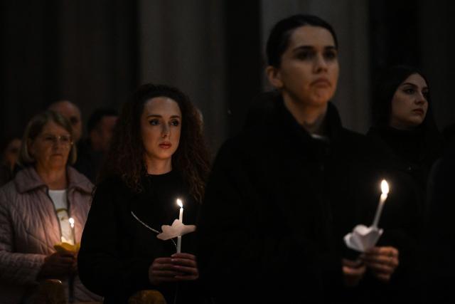 TOPSHOT - Christian worshippers hold candles as they attend an Easter Vigil at the Cathedral of St. Mother Teresa in Pristina, Kosovo on April 4, 2026, as part of the Holy Week celebrations. (Photo by Armend NIMANI / AFP)