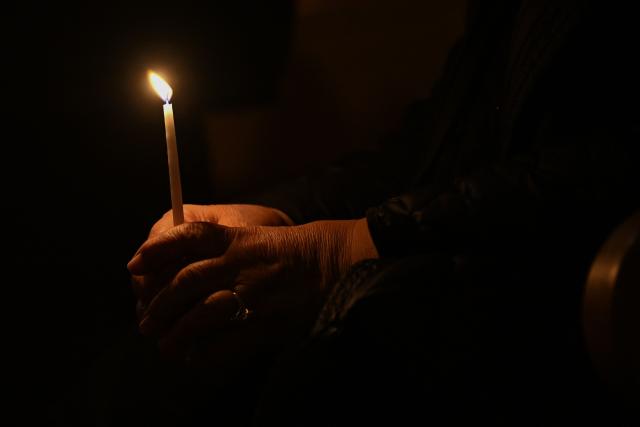 A Christian worshipper holds a candle as she attends an Easter Vigil at the Cathedral of St. Mother Teresa in Pristina, Kosovo on April 4, 2026, as part of the Holy Week celebrations. (Photo by Armend NIMANI / AFP)