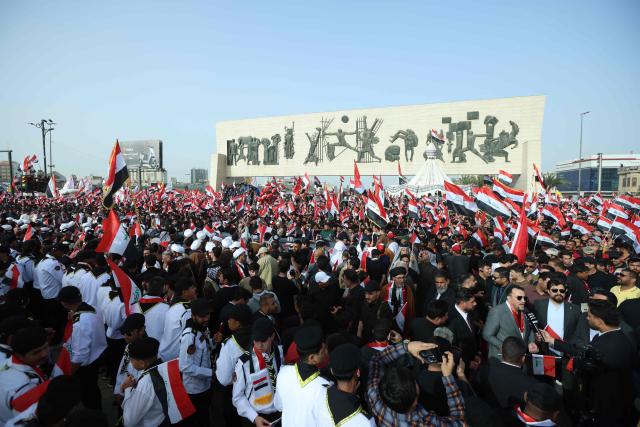 Supporters of Iraqi Shiite cleric Muqtada al-Sadr wave Iraqi flags during a demonstration in Baghdad's Tahrir Square on April 4, 2026. The protest comes following a call by Muqtada al-Sadr for his supporters to demonstrate against the United States and Israel and in condemnation of the war on Iran. (Photo by Murtaja LATEEF / AFP)