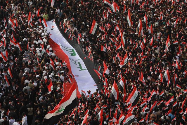 Supporters of Iraqi Shiite cleric Muqtada al-Sadr wave Iraqi flags during a demonstration in Baghdad's Tahrir Square on April 4, 2026. The protest comes following a call by Muqtada al-Sadr for his supporters to demonstrate against the United States and Israel and in condemnation of the war on Iran. (Photo by Murtaja LATEEF / AFP)