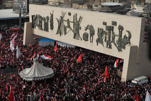 Supporters of Iraqi Shiite cleric Muqtada al-Sadr wave Iraqi flags during a demonstration in Baghdad's Tahrir Square on April 4, 2026. The protest comes following a call by Muqtada al-Sadr for his supporters to demonstrate against the United States and Israel and in condemnation of the war on Iran. (Photo by Murtaja LATEEF / AFP)