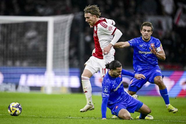 Ajax's Belgian forward #11 Mika Godts (L) vies with FC Twente's Algerian midfielder #06 Ramiz Zerrouki and FC Twente's Dutch defender #28 Bart van Rooij during the Dutch Eredivisie football match between AFC Ajax and FC Twente at the Johan Cruijff ArenA in Amsterdam on April 4, 2026. (Photo by Olaf Kraak / ANP / AFP) / Netherlands OUT