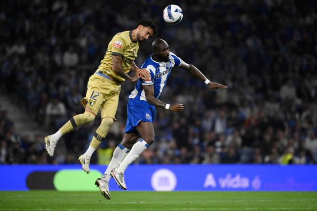FC Famalicão's French forward #12 Simon Elisor and FC Porto's Ivorian midfielder #42 Seko Fofana vie for a header during the Portuguese League football match between FC Porto and FC Famalicao at Dragao stadium in Porto on April 4, 2026. (Photo by Miguel RIOPA / AFP)