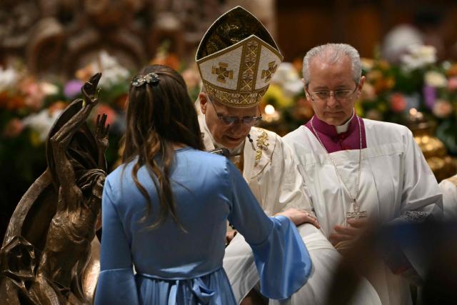 Pope Leo XIV baptizes a woman during the Easter vigil as part of the Holy Week celebrations, at St Peter's basilica in the Vatican on April 4, 2026. (Photo by Andreas SOLARO / AFP)