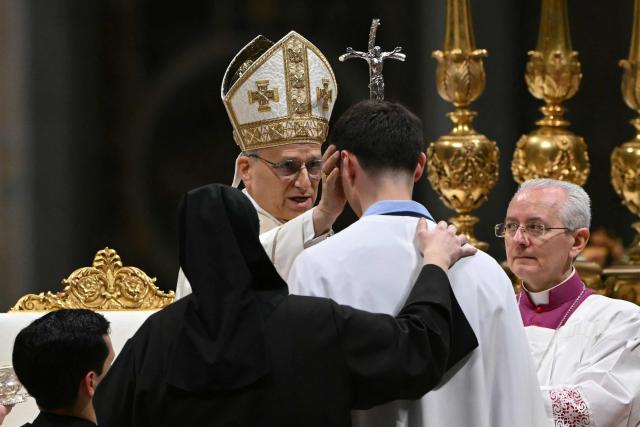 Pope Leo XIV baptizes a man during the Easter vigil as part of the Holy Week celebrations, at St Peter's basilica in the Vatican on April 4, 2026. (Photo by Andreas SOLARO / AFP)