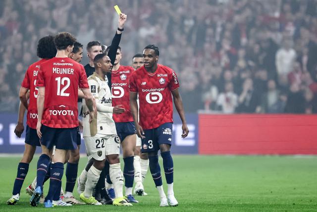 Lille's Belgian defender #03 Nathan Ngoy (R) receives a yellow card after arguing with Lens' players during the French L1 football match between Lille LOSC and RC Lens at the Stade Pierre-Mauroy in Villeneuve-d'Ascq, northern France on April 4, 2026. (Photo by Sameer Al-DOUMY / AFP)