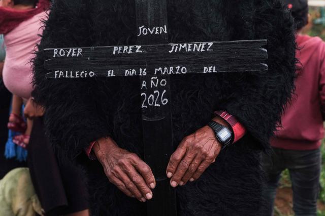 A man holds a cross bearing the name of Royer Perez Jimenez, a 19-year-old Mexican man who was found dead in a US detention center, during his funeral in the Tzotzil indigenous community of San Juan Chamula, Chiapas state, Mexico on April 4, 2026. Thirteen Mexicans have died in raids by US Immigration and Customs Enforcement (ICE), in its custody or in events linked to the agency in the past year, Mexico's government said on March 25, 2026. The most recent case was that of 19-year-old Royer Perez Jimenez, who was found dead in a Florida detention center. Both ICE and the Mexican government gave the presumed cause of death as suicide. (Photo by Luis AGUILAR / AFP)