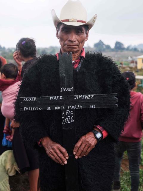 A man holds a cross bearing the name of Royer Perez Jimenez, a 19-year-old Mexican man who was found dead in a US detention center, during his funeral in the Tzotzil indigenous community of San Juan Chamula, Chiapas state, Mexico on April 4, 2026. Thirteen Mexicans have died in raids by US Immigration and Customs Enforcement (ICE), in its custody or in events linked to the agency in the past year, Mexico's government said on March 25, 2026. The most recent case was that of 19-year-old Royer Perez Jimenez, who was found dead in a Florida detention center. Both ICE and the Mexican government gave the presumed cause of death as suicide. (Photo by Luis AGUILAR / AFP)