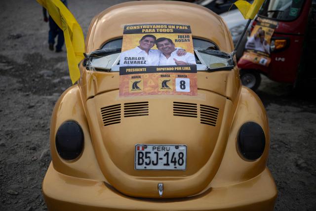 A flyer of Peru's presidential candidate Carlos Alvarez for the Pais Para Todos party and Lima's deputy candidate Julio Rojas is seen on a car during a campaign rally in San Juan de Lurigancho, on the outskirts of Lima, on April 4, 2026. Peru will hold presidential elections on April 12. (Photo by ERNESTO BENAVIDES / AFP)