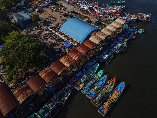 This aerial image shows fishing boats moored to unload the morning's catch at a port in Banda Aceh on April 5, 2026. (Photo by CHAIDEER MAHYUDDIN / AFP)