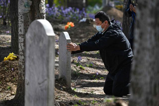 A man pays his respects at the grave of a family member during the annual tomb-sweeping festival, also known as the Qingming festival, near a village east of Beijing on April 5, 2026. (Photo by GREG BAKER / AFP)