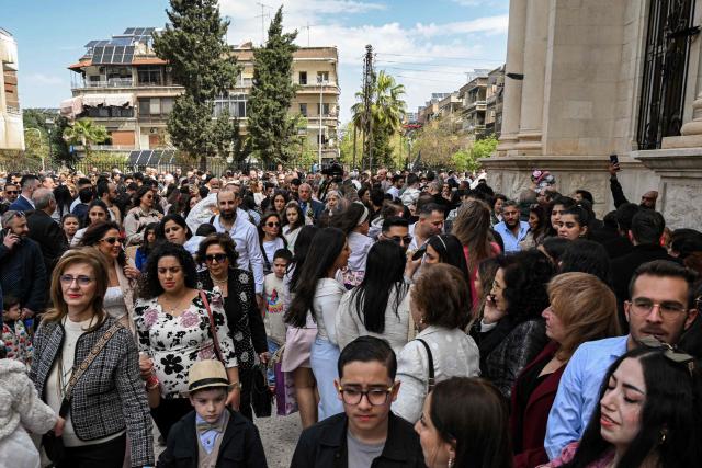 Christian worshippers gather at the Greek Orthodox Church of the Holy Cross in the Qassaa district of Damascus on Orthodox Palm Sunday on April 5, 2026. (Photo by LOUAI BESHARA / AFP)