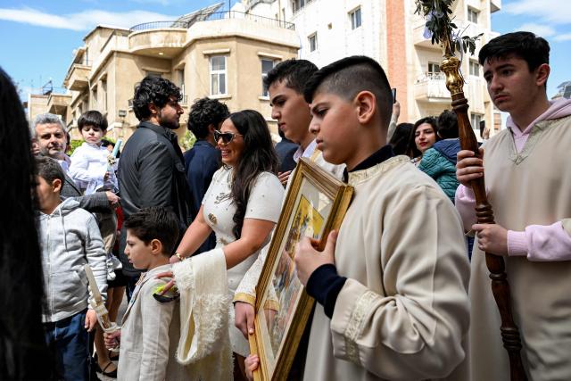 Deacons march with icons in a procession at the Greek Orthodox Church of the Holy Cross in the Qassaa district of Damascus on Orthodox Palm Sunday on April 5, 2026. (Photo by LOUAI BESHARA / AFP)