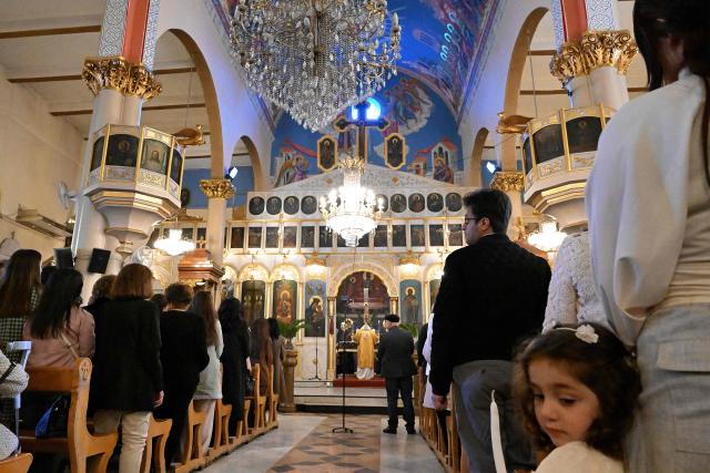 Worshippers attend mass at the Greek Orthodox Church of the Holy Cross in the Qassaa district of Damascus on Orthodox Palm Sunday on April 5, 2026. (Photo by LOUAI BESHARA / AFP)