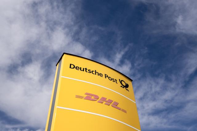 (FILES) A logo of German postal service Deutsche Post and DHL is seen at a logistics center in Dortmund, western Germany, on March 6, 2025. Medicines can stop pain, fight cancer and save lives but are worthless if they get lost in the mail, spoil in a hot warehouse or are stuck on a ship. This is where pharmaceutical logistics comes in -- a fast-growing sector in a world where key supply chains have been shaken by war, pandemic and trade chaos.One of its European hubs is what Germany's DHL calls its health logistics campus near Frankfurt, dedicated to ensuring drugs and other crucial medical products reliably get to where they're needed. (Photo by Ina FASSBENDER / AFP)