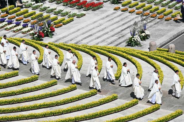 Clergymen walk in procession at the end of the Easter Mass as part of the Holy Week celebrations, at St Peter's square in the Vatican on April 5, 2026. (Photo by Andreas SOLARO / AFP)