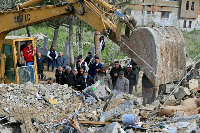 An excavator clears the rubble as first responders look for survivors at the site of an overnight Israeli strike that targeted the southern Lebanese village of Kfar Hatta, on April 5, 2026. An Israeli strike on southern Lebanon's Kfar Hatta, far from the border with Israel, killed seven people on April 5 including a family of six, a source from the Lebanese civil defence told AFP. (Photo by AFP)