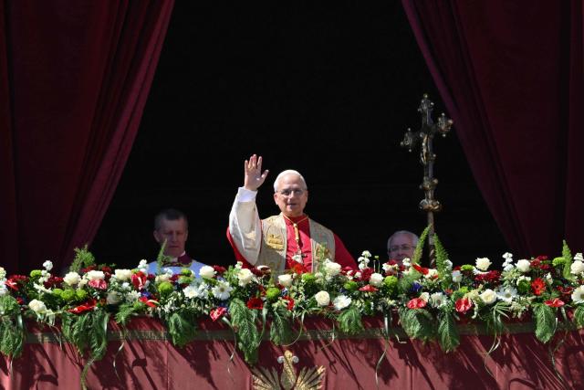 Pope Leo XIV waves to the crowd from the main balcony of St. Peter's basilica for the Urbi et Orbi message and blessing to the city and the world as part of Easter celebrations, at St Peter's square in the Vatican on April 5, 2025. (Photo by Alberto PIZZOLI / AFP)