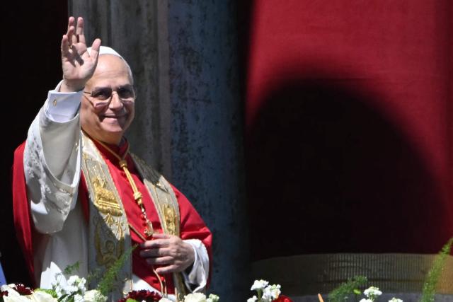 Pope Leo XIV waves to the crowd from the main balcony of St. Peter's basilica for the Urbi et Orbi message and blessing to the city and the world as part of Easter celebrations, at St Peter's square in the Vatican on April 4, 2025. (Photo by Andreas SOLARO / AFP)