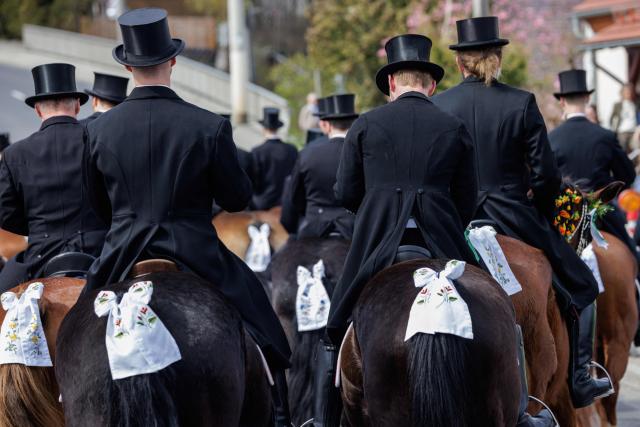 Sorbian horsemen dressed in traditional black attire sing as they ride on decorated horses during the Sorbian Easter horseback procession, on Easter Sunday, April 05, 2026 at the St Marienstern monastery in Panschwitz-Kuckau eastern Germany. This ancient religious ritual involves Sorbs riding decorated horses while singing to announce the resurrection of Jesus Christ. The Sorbs are a Slavic minority residing in eastern Germany near the German-Polish border. (Photo by JENS SCHLUETER / AFP)