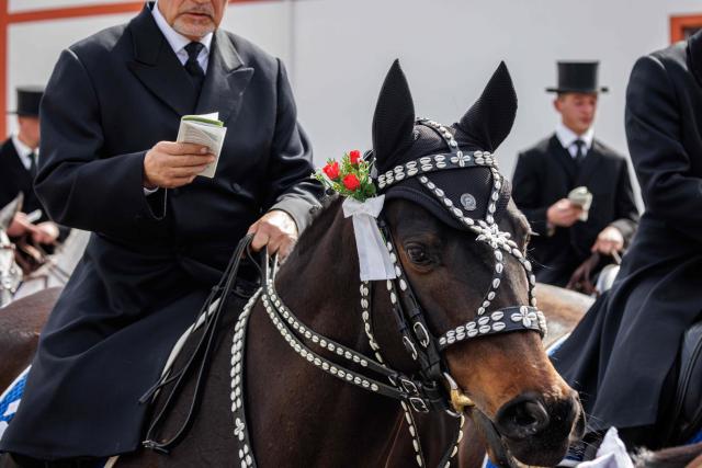 Sorbian horsemen dressed in traditional black attire sing as they ride on decorated horses during the Sorbian Easter horseback procession, on Easter Sunday, April 05, 2026 at the St Marienstern monastery in Panschwitz-Kuckau eastern Germany. This ancient religious ritual involves Sorbs riding decorated horses while singing to announce the resurrection of Jesus Christ. The Sorbs are a Slavic minority residing in eastern Germany near the German-Polish border. (Photo by JENS SCHLUETER / AFP)