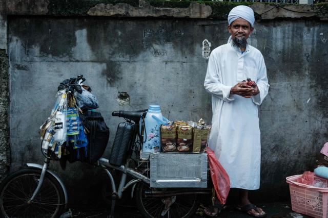 A man selling coffee from a bicycle waits for customers on a street in Jakarta on April 4, 2026. (Photo by YASUYOSHI CHIBA / AFP)